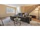Spacious living room featuring a large window, staircase, and comfortable seating area at 5573 S Lowell Blvd, Littleton, CO 80123