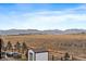 Backyard with mountain views, storage shed and outdoor fireplace seating area at 8695 Torrey St, Arvada, CO 80007