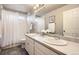 Bright bathroom features a double sink vanity, neutral paint, tiled shower and gray floor at 8695 Torrey St, Arvada, CO 80007