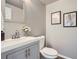 Neutral powder bath featuring a gray vanity, framed mirror, and decorative wall art at 8695 Torrey St, Arvada, CO 80007