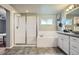 Bright bathroom featuring a shower, a tub, and a sink with vanity at 8695 Torrey St, Arvada, CO 80007