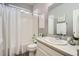 Well-lit bathroom featuring a shower over tub, toilet, sink with vanity, and decor at 8695 Torrey St, Arvada, CO 80007