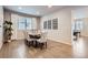 Bright dining area featuring a modern table set, wood floors, and a large window for natural light at 8695 Torrey St, Arvada, CO 80007