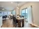 Bright dining area features wood floors, sliding glass door to deck with views of mountains and an open concept to the living room at 8695 Torrey St, Arvada, CO 80007