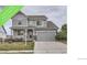 Charming two-story home featuring a well-manicured lawn, stone accents, and an attached two-car garage at 8695 Torrey St, Arvada, CO 80007