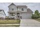 Charming two-story home featuring a well-manicured lawn, stone accents, and an attached two-car garage at 8695 Torrey St, Arvada, CO 80007