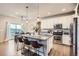 Modern kitchen with white cabinets, a granite island with seating, and stainless steel appliances at 8695 Torrey St, Arvada, CO 80007