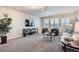 Open living room with natural light from windows, plush carpet and comfortable seating furniture at 8695 Torrey St, Arvada, CO 80007