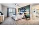 Bright main bedroom featuring an accent wall, carpet, and a view of the en suite bath at 8695 Torrey St, Arvada, CO 80007