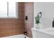 Close up of shower tile with white vanity with white countertop and silver hardware at 2542 S Winona Ct, Denver, CO 80219