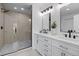 Modern bathroom featuring double vanity, sleek fixtures, and frameless glass shower at 2542 S Winona Ct, Denver, CO 80219