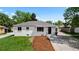 Charming exterior showcasing a white brick home with updated windows and professional landscaping at 2542 S Winona Ct, Denver, CO 80219