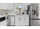 Updated kitchen featuring stainless steel appliances, modern cabinets, quartz counters, and subway tile backsplash at 2542 S Winona Ct, Denver, CO 80219
