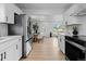 Updated kitchen with stainless steel appliances, bright white cabinets, and open layout at 2542 S Winona Ct, Denver, CO 80219