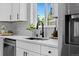 Modern kitchen with quartz countertops, white cabinets, and stainless steel appliances provides an efficient and updated space at 2542 S Winona Ct, Denver, CO 80219