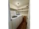 Functional laundry room with a washer, dryer and shelving for storage solutions at 12470 E Cornell Ave # 203, Aurora, CO 80014
