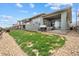 Backyard featuring a patio, grill, and grassy area lined with rocks at 19409 W 88Th Dr, Arvada, CO 80007