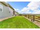 Spacious backyard with lush green grass, stone landscaping, and a charming wooden fence at 19409 W 88Th Dr, Arvada, CO 80007