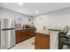 Basement bar with dark wood cabinets, a sink, and a stainless-steel refrigerator at 19409 W 88Th Dr, Arvada, CO 80007