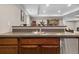 Basement bar with a dark countertop, stainless steel sink, and dark wood cabinets at 19409 W 88Th Dr, Arvada, CO 80007