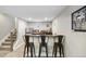 Finished basement bar area with seating, wood cabinets, and stainless-steel refrigerator at 19409 W 88Th Dr, Arvada, CO 80007