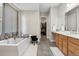 Luxurious bathroom with a standalone tub, double vanity, and walk-in closet at 19409 W 88Th Dr, Arvada, CO 80007
