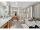 Spacious bathroom featuring double vanities, a glass shower, and a standalone tub at 19409 W 88Th Dr, Arvada, CO 80007