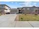 Single Gathering home with two car garage, stone accents, and a well kept driveway at 19409 W 88Th Dr, Arvada, CO 80007