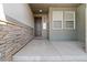 Covered front porch with decorative stone accents and a welcoming entryway, providing curb appeal at 19409 W 88Th Dr, Arvada, CO 80007