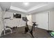 Home gym with ceiling lighting, a large Peloton bike, and a TV at 19409 W 88Th Dr, Arvada, CO 80007