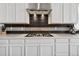 Contemporary gas cooktop in stylish kitchen featuring white cabinets and range hood at 19409 W 88Th Dr, Arvada, CO 80007