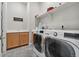 Modern laundry room with tile floors, washer, dryer, and shelving at 19409 W 88Th Dr, Arvada, CO 80007