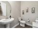 Chic powder room with pedestal sink, toilet, and stylish decor on the wall at 19409 W 88Th Dr, Arvada, CO 80007