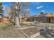 Large backyard with garden beds, mature trees, and a patio set, perfect for outdoor relaxation at 1255 S Hoyt St, Lakewood, CO 80232