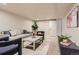 Well-lit basement living room with a comfortable sofa, stylish chairs, and simple decor at 1255 S Hoyt St, Lakewood, CO 80232