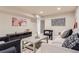 Neutral basement living room with modern sofa, textured chairs, and decorative art at 1255 S Hoyt St, Lakewood, CO 80232