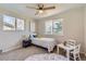 Bright, cozy bedroom with a twin bed, ceiling fan, large windows, and playful decor accents at 1255 S Hoyt St, Lakewood, CO 80232