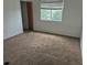 A bedroom features neutral carpet, natural light from a window, and a closet at 1415 S Pitkin Ct, Aurora, CO 80017