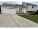 Tan two-story home featuring an attached garage and stone accents, perfect for suburban living at 1415 S Pitkin Ct, Aurora, CO 80017