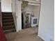 Laundry area with modern washer and dryer beside staircase with neutral carpet at 1415 S Pitkin Ct, Aurora, CO 80017