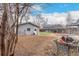 Backyard of the home with a detached garage, patio area, small lawn, and mature trees at 117 6Th St, Frederick, CO 80530