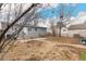 Back exterior of home and yard with patio, garden, and mature trees at 117 6Th St, Frederick, CO 80530