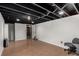 Unfinished basement with exposed ceiling, vinyl floors, and access to other rooms at 117 6Th St, Frederick, CO 80530