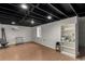 Open basement area with exposed ceiling, vinyl floors and a shelf for storage at 117 6Th St, Frederick, CO 80530