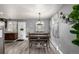 Grey-toned dining room with wood floors, modern lighting and decor at 117 6Th St, Frederick, CO 80530