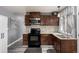 Stylish kitchen features dark wood cabinetry, stone countertops, modern appliances, and a gray backsplash at 117 6Th St, Frederick, CO 80530