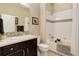 Bathroom featuring dark wood cabinets, neutral countertops, and a shower-tub combo with mosaic tile at 8272 E 55Th Pl, Denver, CO 80238