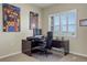 Home office with a large desk, comfortable chair, and natural light from a window with shutters at 8272 E 55Th Pl, Denver, CO 80238