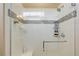 Walk-in shower featuring white tile, mosaic accents, a built-in bench, and a modern showerhead at 8272 E 55Th Pl, Denver, CO 80238