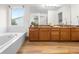 Bright bathroom featuring a tub and a spacious vanity with granite countertops at 8164 S York Ct, Centennial, CO 80122